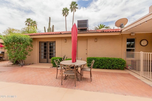 view of patio featuring outdoor dining area, central air condition unit, and french doors