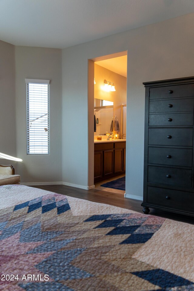 bedroom featuring connected bathroom and dark hardwood / wood-style floors