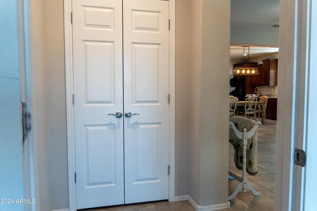 hallway featuring a notable chandelier and light tile patterned floors