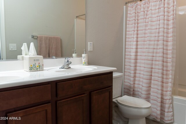 full bathroom with shower / bath combo with shower curtain, vanity, and toilet