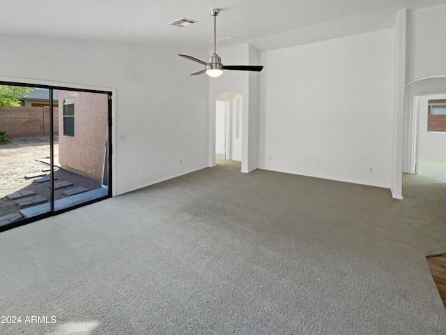 unfurnished living room featuring carpet floors, ceiling fan, and vaulted ceiling