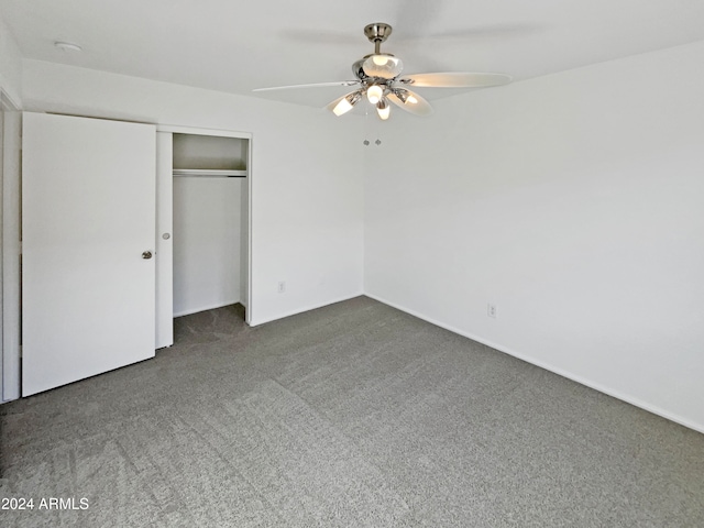 unfurnished bedroom featuring a closet, dark carpet, and ceiling fan