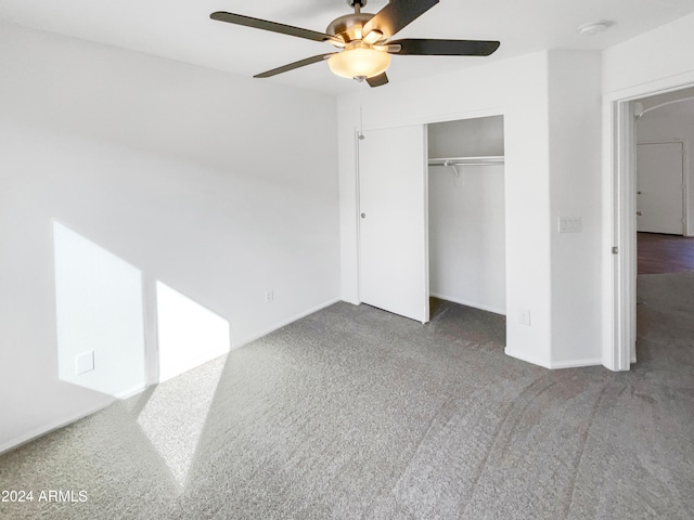 unfurnished bedroom featuring ceiling fan, a closet, and dark carpet