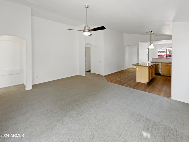 unfurnished living room with dark carpet and ceiling fan