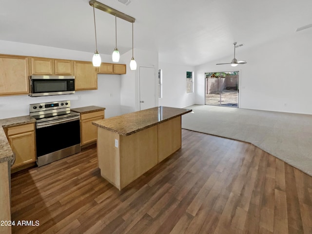 kitchen with stainless steel appliances, dark stone countertops, decorative light fixtures, vaulted ceiling, and dark hardwood / wood-style flooring