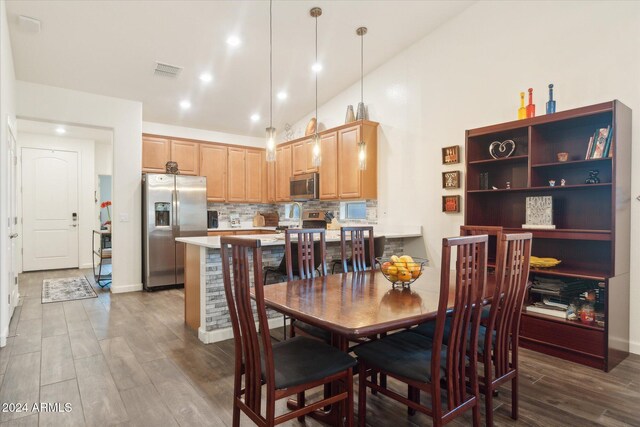 dining area with dark hardwood / wood-style flooring, high vaulted ceiling, and sink