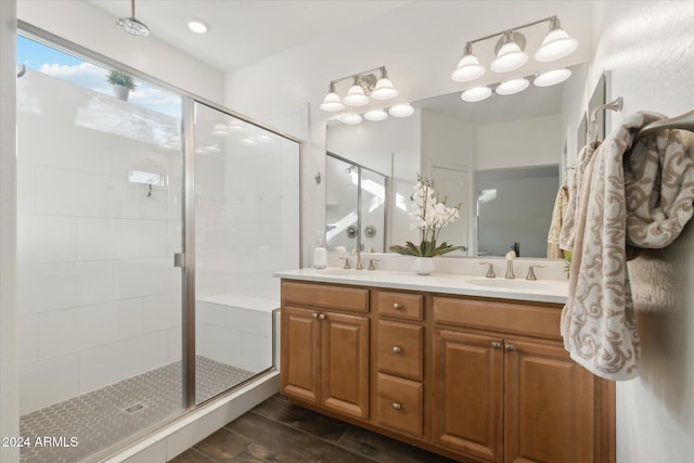 bathroom featuring a shower with door and vanity