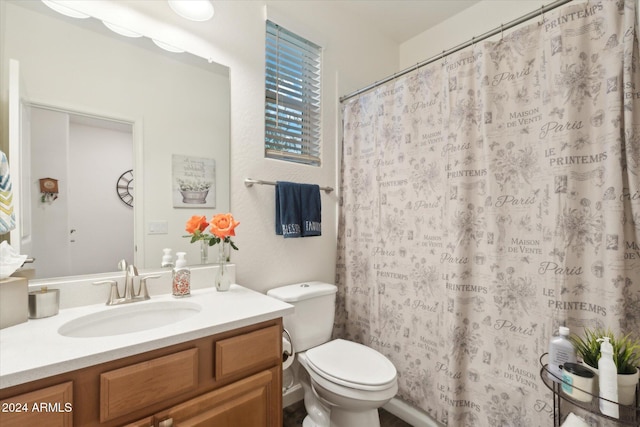 bathroom with curtained shower, vanity, and toilet