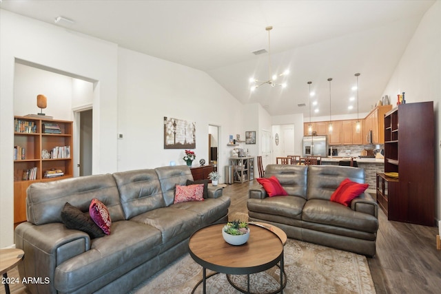 living room featuring dark hardwood / wood-style floors, lofted ceiling, and a chandelier