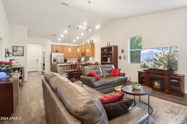 living room featuring vaulted ceiling and light hardwood / wood-style flooring