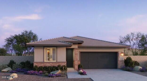 22376 W Monona Ln, Surprise, AZ 85387 - prairie-style house featuring an attached garage, fence, concrete driveway, and brick siding