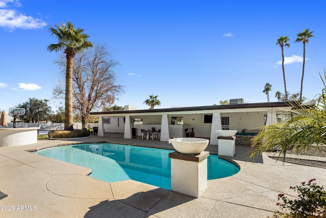 view of swimming pool featuring exterior kitchen, an outdoor bar, and a patio