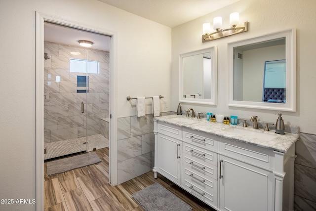 bathroom with vanity, tile walls, and an enclosed shower