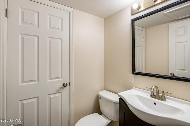 bathroom featuring vanity, a textured ceiling, and toilet