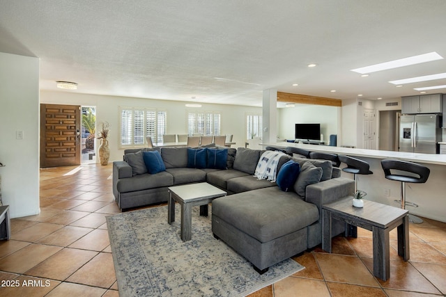 living room featuring a textured ceiling and light tile patterned floors