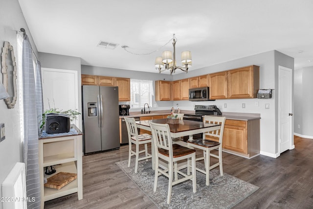 2412 W Camp River Rd, San Tan Valley, AZ 85144 - kitchen with dark wood finished floors, a chandelier, stainless steel appliances, and visible vents