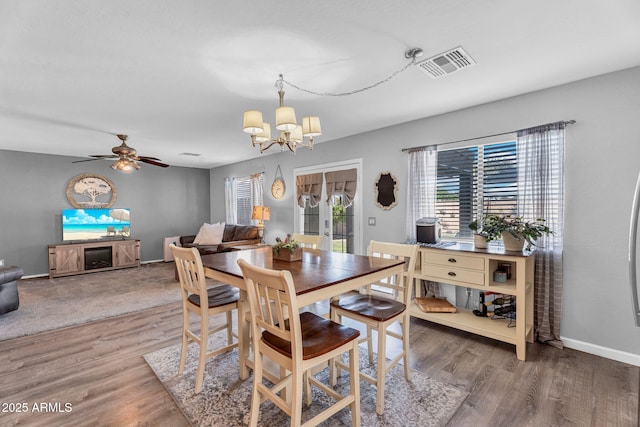 2412 W Camp River Rd, San Tan Valley, AZ 85144 - dining room featuring ceiling fan with notable chandelier, baseboards, wood finished floors, and visible vents