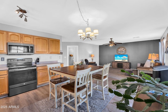 2412 W Camp River Rd, San Tan Valley, AZ 85144 - kitchen featuring ceiling fan with notable chandelier, light countertops, wood finished floors, and appliances with stainless steel finishes
