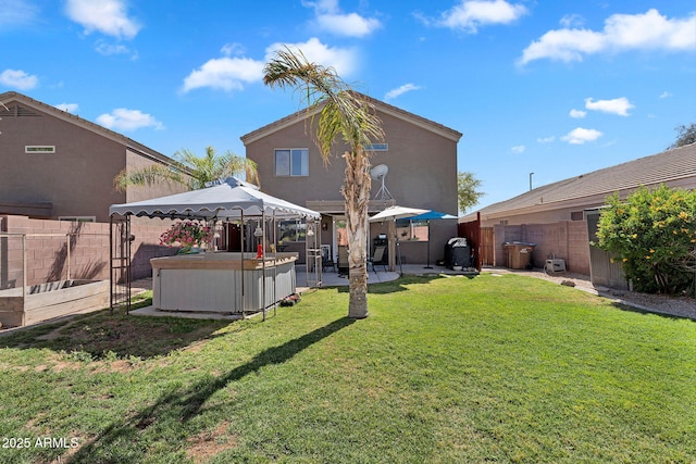 2412 W Camp River Rd, San Tan Valley, AZ 85144 - back of property featuring a lawn, a jacuzzi, a fenced backyard, and a gazebo