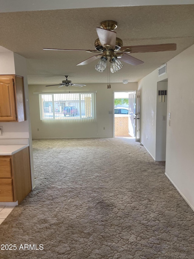 unfurnished living room featuring light carpet and a textured ceiling