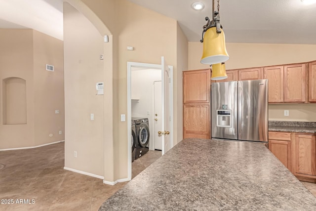 kitchen with stainless steel fridge with ice dispenser, arched walkways, washer and clothes dryer, lofted ceiling, and dark countertops