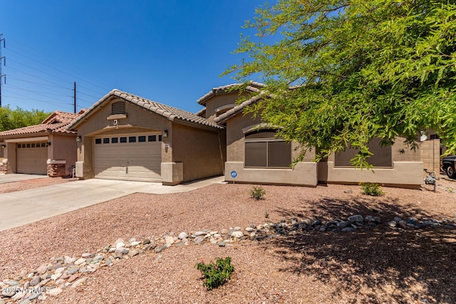 view of front of property with stucco siding, a garage, a tile roof, and driveway