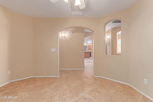 tiled empty room with arched walkways and baseboards
