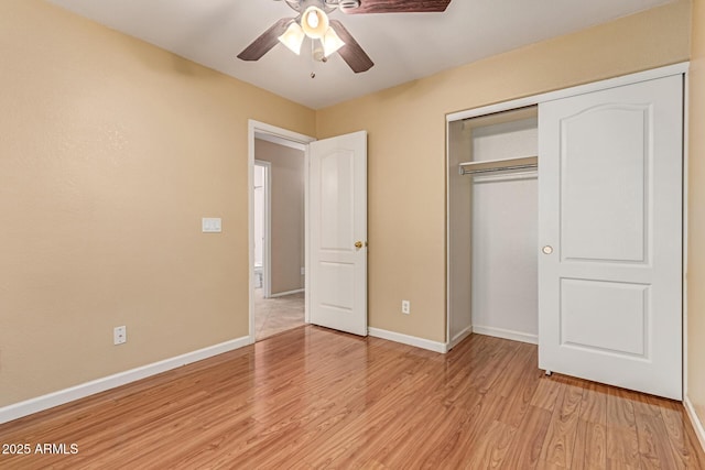 unfurnished bedroom featuring baseboards, light wood-type flooring, a closet, and a ceiling fan