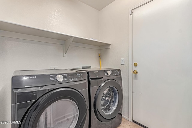 laundry room with washer and dryer and light tile patterned flooring