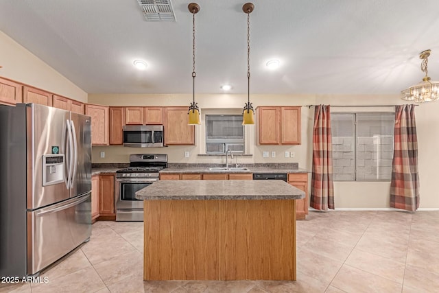 kitchen featuring stainless steel appliances, a sink, a center island, light tile patterned floors, and dark countertops