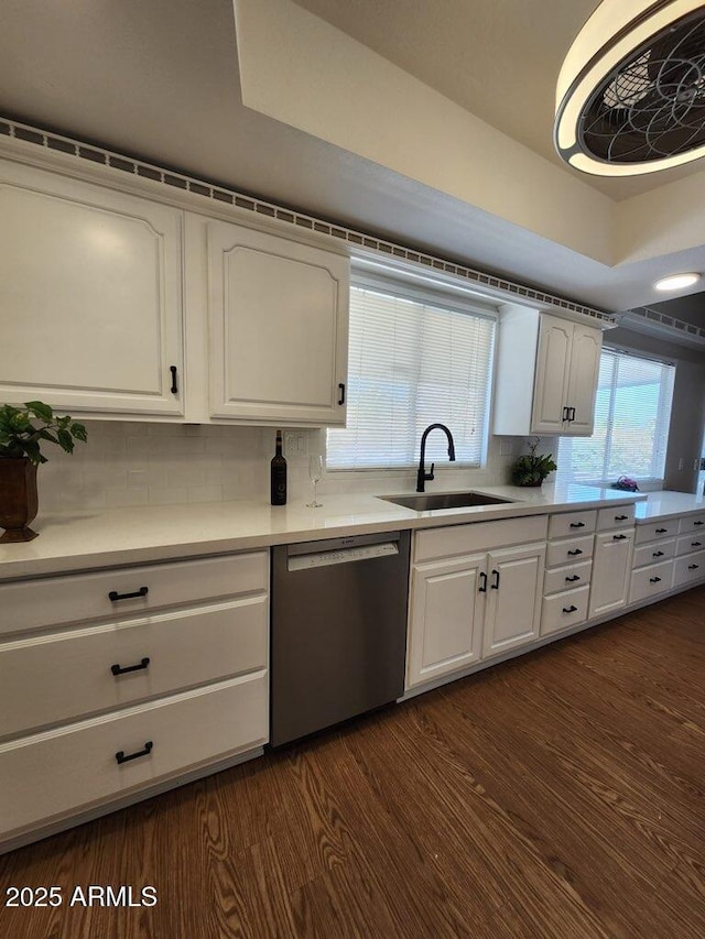 kitchen with dishwasher, white cabinetry, a sink, tasteful backsplash, and dark wood-style flooring