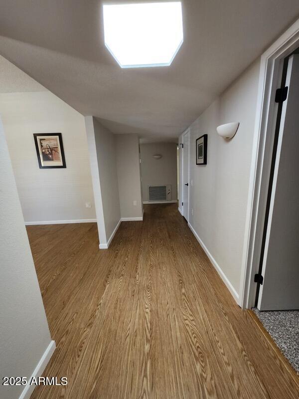 hallway with baseboards and wood finished floors