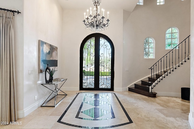 entryway with a chandelier, a high ceiling, and french doors