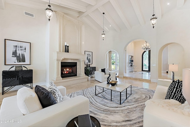 living room with beam ceiling, a high ceiling, and a chandelier