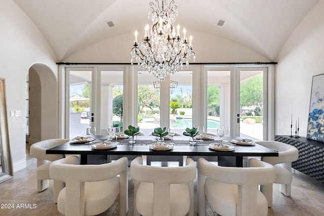 dining space featuring lofted ceiling, french doors, and a chandelier