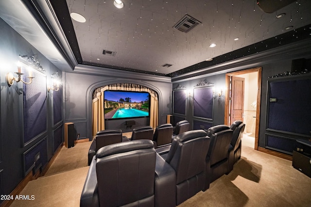 home theater with carpet floors, crown molding, and a tray ceiling