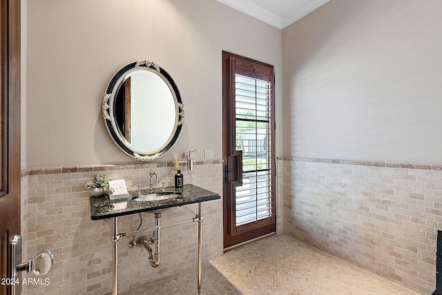 bathroom featuring tile walls, crown molding, and sink