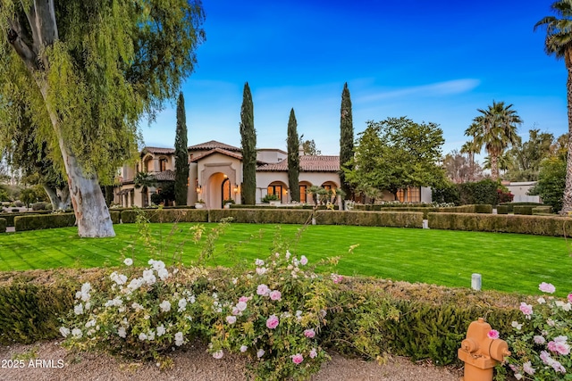 mediterranean / spanish-style house featuring a front lawn