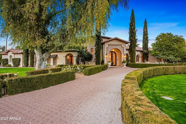 mediterranean / spanish home with a front lawn