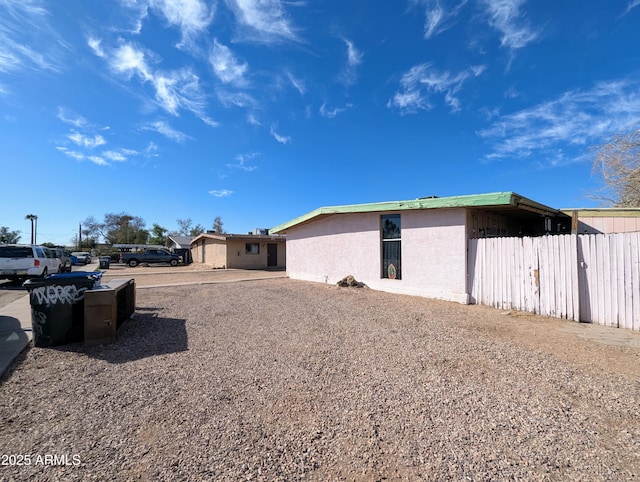 view of property exterior with fence and stucco siding