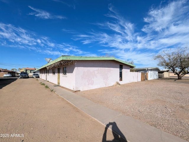 view of home's exterior with fence and stucco siding