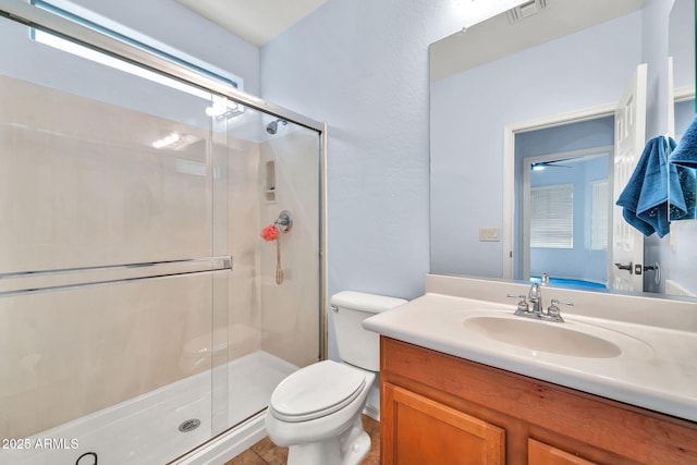 bathroom featuring toilet, vanity, and a stall shower