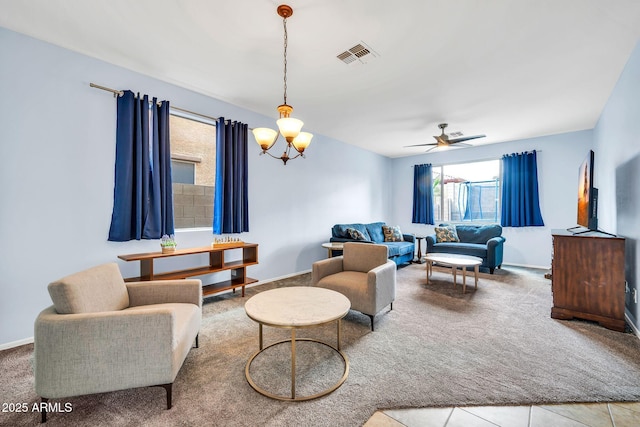 living room featuring a chandelier, carpet flooring, a ceiling fan, and baseboards