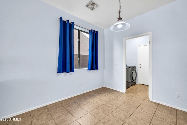 unfurnished room featuring light tile patterned floors, baseboards, and washer and dryer