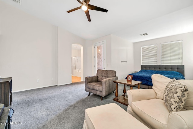 living room with a ceiling fan, arched walkways, carpet floors, and baseboards