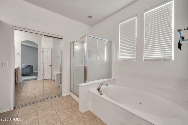 bathroom featuring a shower stall, a bath, and tile patterned flooring