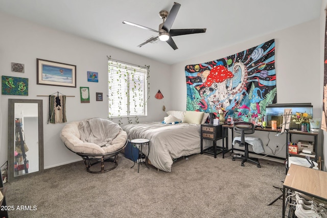carpeted bedroom with ceiling fan and baseboards