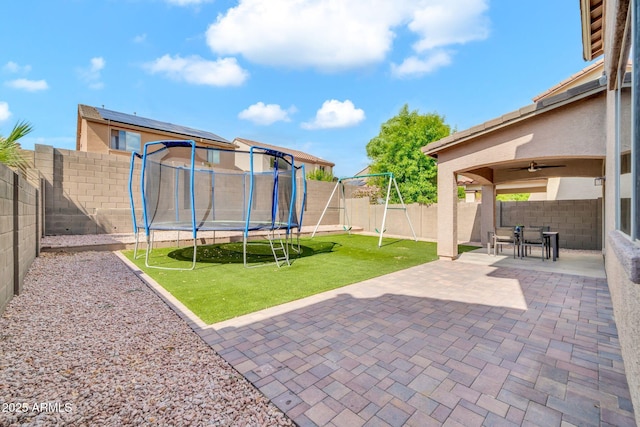 view of yard with a trampoline and a patio