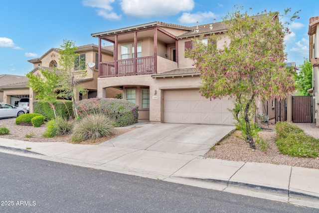 view of front of house featuring a balcony, stucco siding, a garage, and driveway