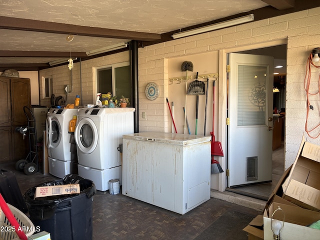 laundry area featuring washer and dryer and concrete block wall